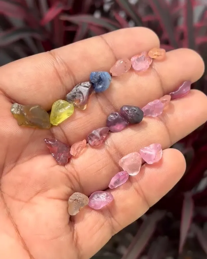 Mixed lot of rough gemstones in the palm of a hand