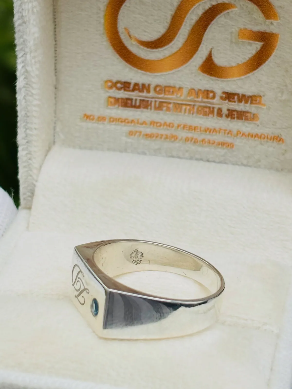 Silver signet-style ring with a blue topaz