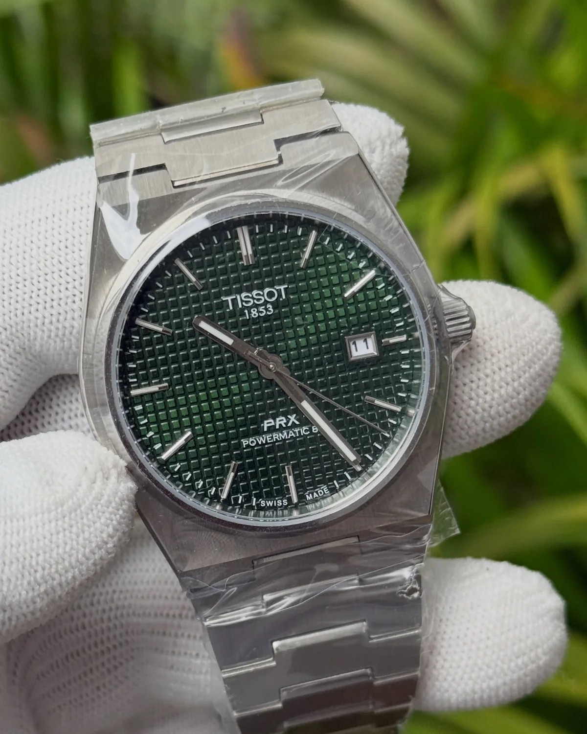 Green-dial round-case watch with an integrated bracelet, photographed by Ocean Gem & Jewel
